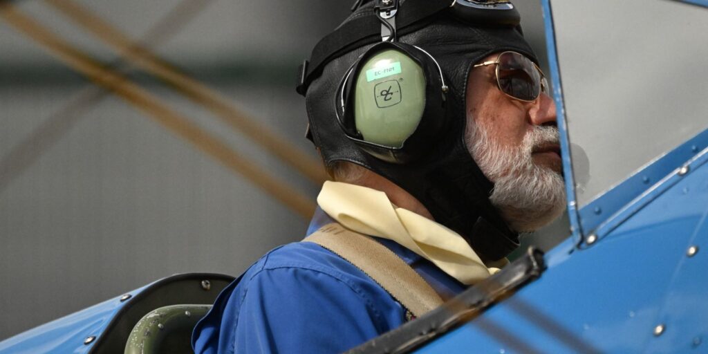 Portré egy aviátorról vintage repülős felszerelésben, felszállásra készülve